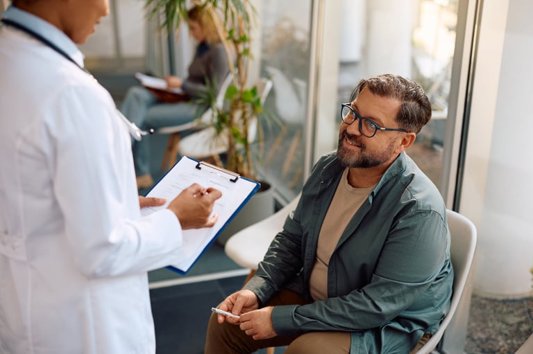 Happy mature man communicating with a doctor in waiting room at the clinic