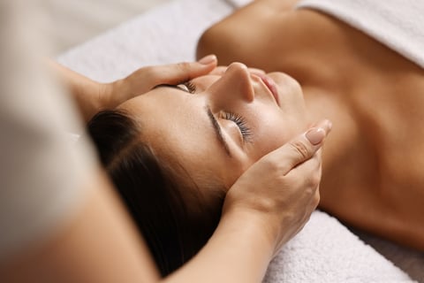 Attractive woman enjoying face massage, closeup